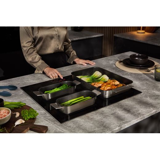 Siemens IQ-700 EX675HXC1E 60cm Induction Hob - Black - person cooking on hob