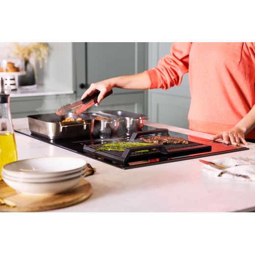 NEFF V68AUX4C0 Induction Hob Black - Person cooking food on hob shot