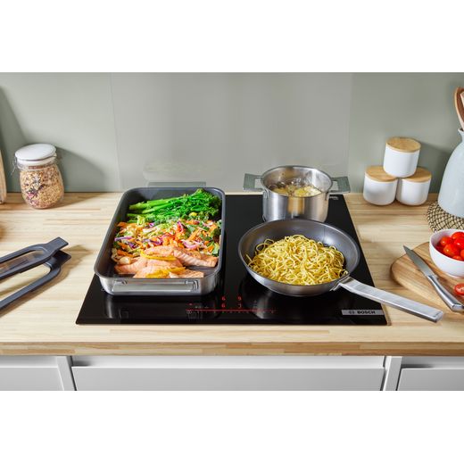 Bosch Series 6 PIX631HC1E 59cm Induction Hob - Black - food cooking on hob shot