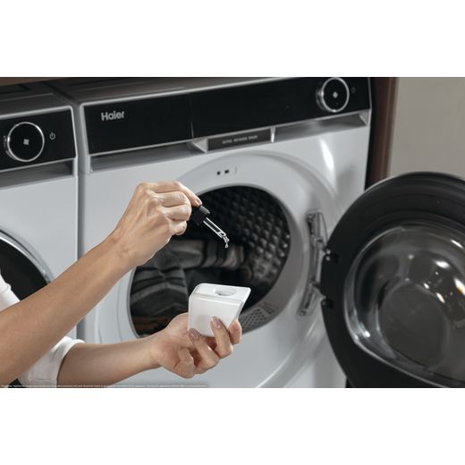 Haier X11 Series HD90-A3Q97U1 Wifi Connected 9Kg Heat Pump Tumble Dryer - White - Man adding scent boost in tumbler dryer shot