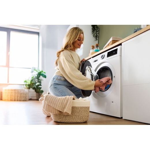 Bosch Series 6 10.5Kg / 6Kg Washer Dryer - White - Women putting clothes in washer dryer shot