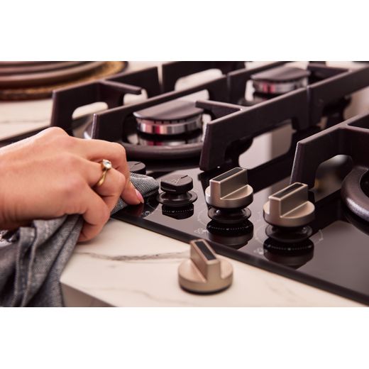 NEFF N70 T26PIP4S0 59cm Gas Hob - Black - person cleaning dial shot