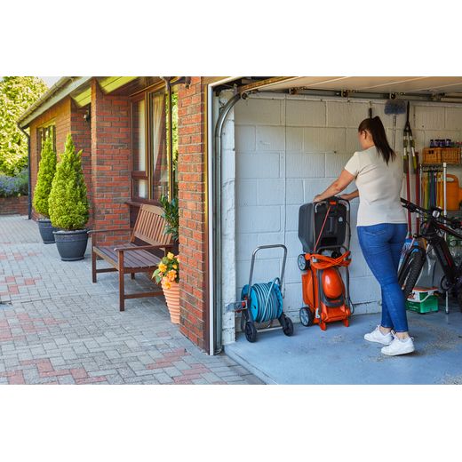 Flymo EasiStore 340R Corded Lawn Mower - Black / Orange - person in garage with mower shot