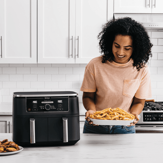 Ninja Foodi Max Dual Zone AF400UK Air Fryer - Black - Women with cooked food from air fryer shot