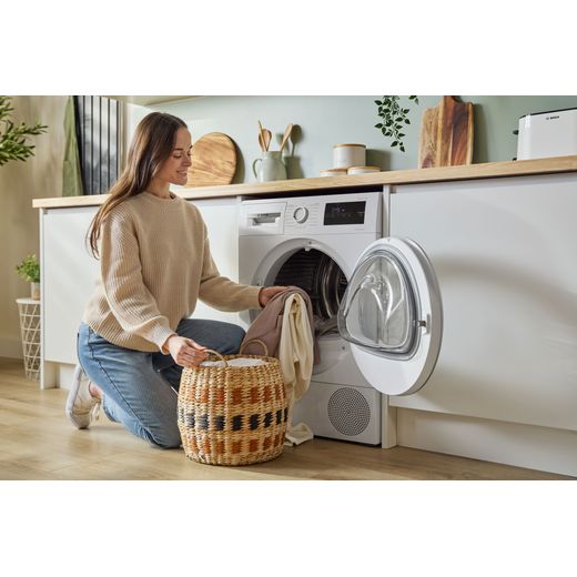 Bosch Series 4 WTH85226GB 8Kg Heat Pump Tumble Dryer - White  - women loading machine shot