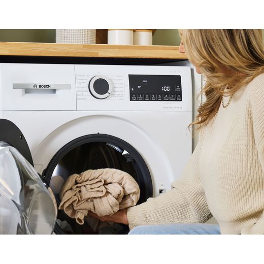 Bosch Series 6 10.5Kg / 6Kg Washer Dryer - White - Women putting clothes in dryer shot